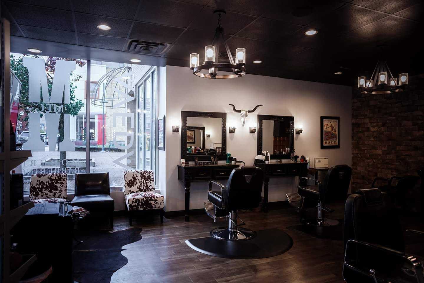 Barbershop interior with leather chairs, mirrors, and dim lighting.